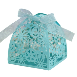 Laser-cut wedding favor box in light blue with floral patterns and a ribbon bow