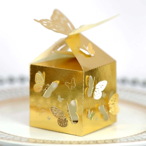 Elegante scatola per bomboniere a farfalla dorata tagliata al laser per caramelle su piatto di ceramica