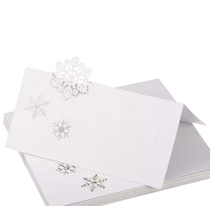 Elegant white laser-cut snowflake place cards with shimmer texture for wedding tables
