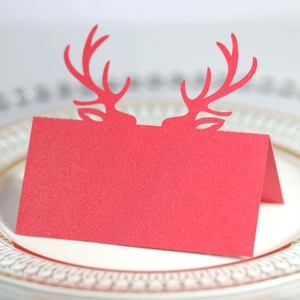 Elegante segnaposto rosso a forma di renna tagliato al laser su un piatto di ceramica bianca