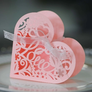 Pink heart-shaped laser-cut LOVE candy box with white ribbon for wedding gifts
