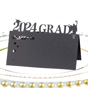 Laser-cut 2024 graduation place card with Class Of silhouette on a white dinner plate