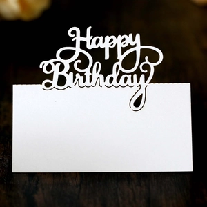 White cutout Happy Birthday place card on dark wood table for party table decoration