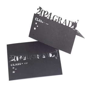 Detail of 2024 graduation laser-cut seat cards with silhouettes of graduates tossing caps
