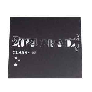 Detailed laser-cut 2024 GRAD seat card with Class of text and hollow star patterns