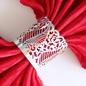 Iridescent laser-cut vine patterned napkin ring on a deep red napkin for table decor
