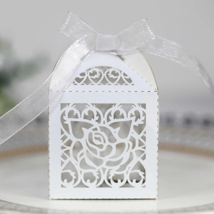 Close-up of laser-cut white rose paper candy box with elegant organza ribbon bow