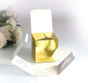 Detailed view of square gold hollow-out favor box with ornate Arabic pattern belt