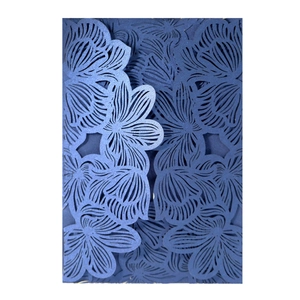 Detail of dark blue laser-cut invitation card with intricate floral patterns and pearlescent finish
