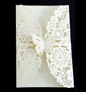 Elegant white laser-cut wedding invitation featuring intricate floral lace and a 3D butterfly