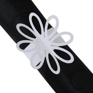 Elegante servilletero de flor blanca cortada por láser en una servilleta negra de mesa