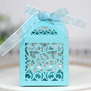 Light blue laser-cut wedding favor box with rose pattern and silk ribbon detail