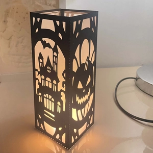 Halloween black paper lantern featuring laser-cut pumpkin and castle with warm LED glow