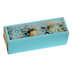 Laser-cut light blue hollow gift box with floral patterns holding chocolate truffles