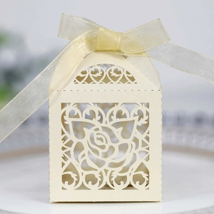 Detailed macro view of laser-cut rose design and champagne ribbon bow on favor box