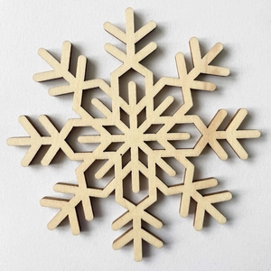 Laser-cut wooden snowflake coaster with intricate hollow pattern for holiday table decor