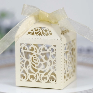 Detail of laser-cut rose hollow favor box with pearlescent finish and ribbon bow