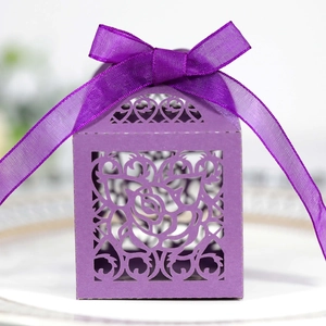 Close-up of a purple laser-cut rose wedding candy box with a matching silk ribbon bow