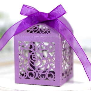 Close-up of laser-cut purple candy box with rose patterns and a satin ribbon bow