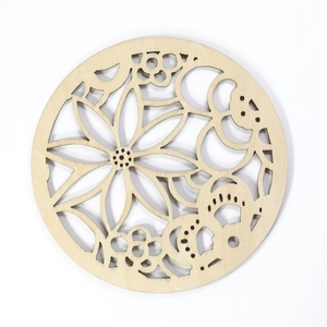 Laser-cut floral wood coaster with a circular design and detailed natural wood grain