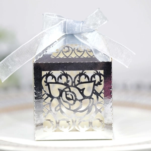 Detailed macro view of silver laser-cut rose hollow candy box with silk ribbon bow