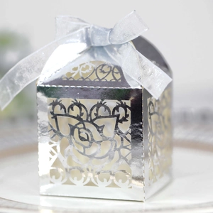 Detailed close-up of silver laser-cut wedding favor box with elegant ribbon bow