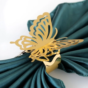 Detailed view of a golden metal butterfly napkin ring with intricate laser-cut hollow pattern