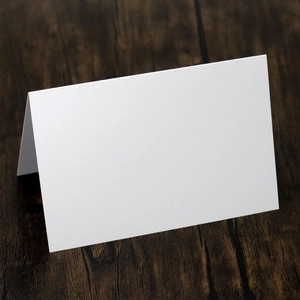 Stereo ice white place cards made of 250g hollow cardstock for weddings on a wood desk
