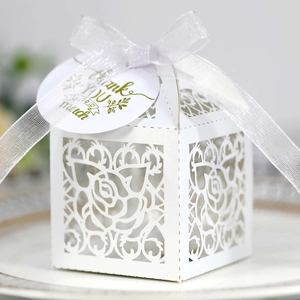 Macro view of white laser-cut rose gift box with organza ribbon and Thank You tag