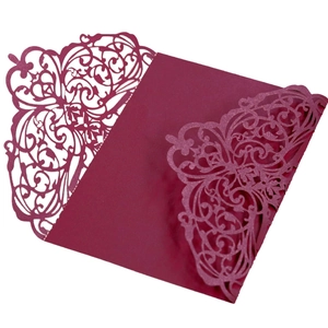 Elegant laser-cut burgundy invitation suite with intricate floral patterns and glitter finish