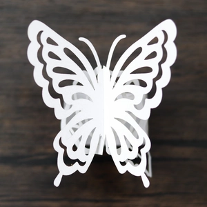 Detail of laser-cut white paper butterfly napkin ring with intricate hollow pattern