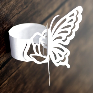 Close-up of white laser-cut butterfly napkin ring with intricate floral patterns