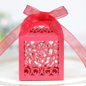 Elegant red laser-cut wedding favor box with rose patterns and a red organza ribbon bow