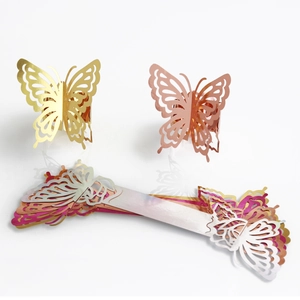 Macro detail of laser-cut butterfly napkin rings in vibrant metallic finishes