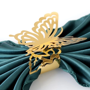 Servilletero de mariposa dorada con diseño calado sobre tela de raso verde