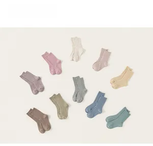 Detail showing ten pairs of rib-knit children socks in various Morandi earth tones