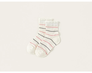 Gros plan de chaussettes en coton côtelé pour filles avec bords à volants et rayures