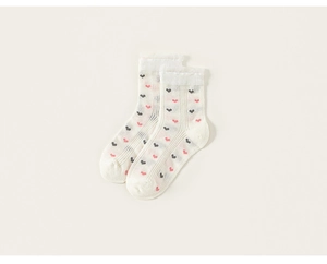 Détail de chaussettes blanches pour filles avec motifs cœurs et bords volantés