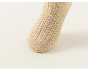 Close-up of beige ribbed knit cotton socks showing detailed stitching on the toes