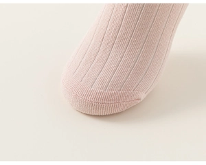 Gros plan détaillé montrant le tissu en maille côtelée rose doux et les coutures de précision