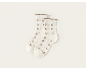 Détail de chaussettes enfant crème avec motif fraise et poignets à volants