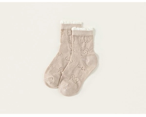 Vue détaillée de chaussettes en coton beige pour bébé avec motifs lapins et bord en dentelle