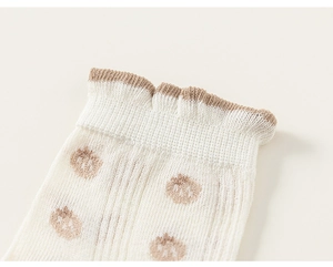 Gros plan de chaussettes en résille avec bord festonné marron et motif fraise