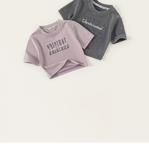 Détail de t-shirts en coton pour enfants avec col rond et broderie de lettres