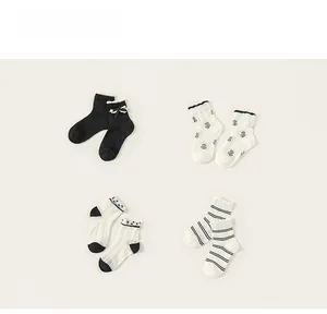 Vue détaillée de quatre chaussettes en coton avec dentelle et divers motifs noirs et blancs