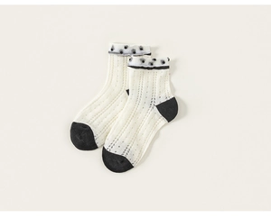 Détails de chaussettes en maille contrastée, corps crème et bordure en dentelle à pois noirs