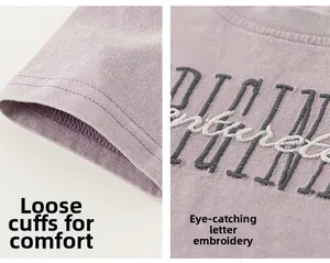 Détail du t-shirt en coton lavande avec poignets larges et broderie de lettres de qualité
