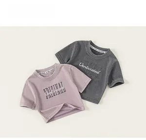 Détail de crop tops en coton violet et gris avec lettrage brodé sur la poitrine