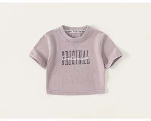 Détail du t-shirt en coton lavande avec broderie de lettres et texture douce de qualité