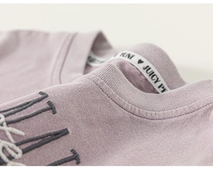 Vue macro du t-shirt enfant lavande montrant le tissu en coton doux et la broderie